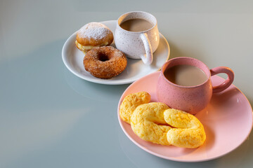 rustic porcelain cups with cappuccino, cheese bread with parmesan, known as chipa, dream and donuts