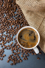hot delicious aromatic coffee black espresso in a white cup on a background of coffee beans