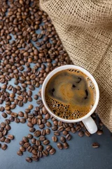 Crédence de cuisine en plexiglas Café hot delicious aromatic coffee black espresso in a white cup on a background of coffee beans