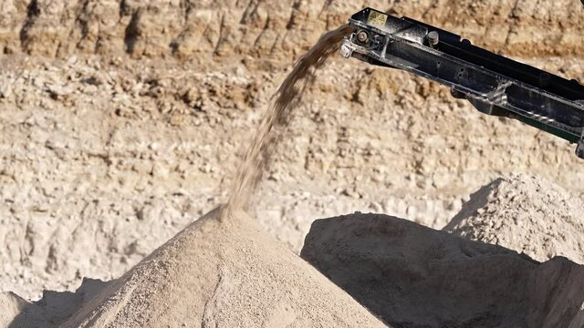 Mobile portable crushing screening plant. Mining conveyor belt sorts rock and loading stones in truck. Heavy machinery working for minerals extraction. Mining extractive industry.
