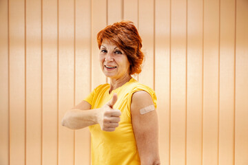 Vaccination and inoculation during covid 19. A happy woman approving vaccination and showing arm...