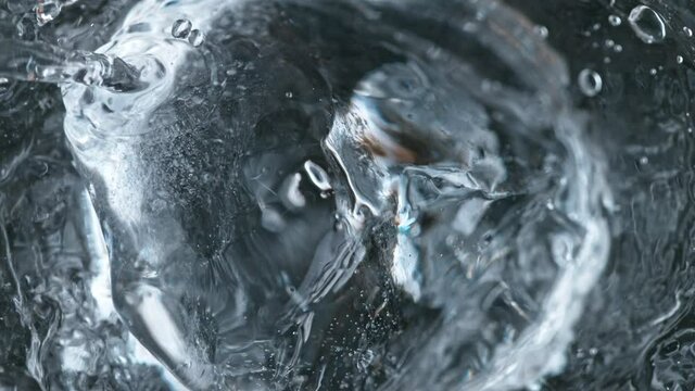 Super slow motion of falling ice cube into Vodka drink. Overhead shot. Filmed on high speed cinema camera, 1000fps.