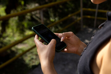 Woman hands with cell phone in hand, natural light. short shot. Technology concept.