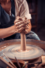 production process of pottery. Forming a clay teapot on a potter's wheel.