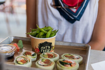 Low carbohydrate sushi roll pieces, with side of edamame on food court tray