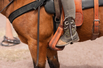 Close up of a cowgirl's foot riding a horse