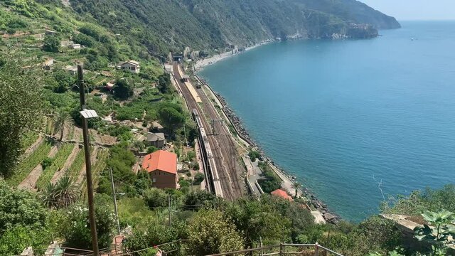 Italian Trenitalia train arrives at Corniglia (Cinque Terre) train, railway station in mountains. Italian riviera Mediterranean sea coastline.  Corniglia, Cinque Terre, Liguria, Italy.