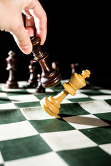 Playing chess on a foldable board. Close ups of some important pieces. 