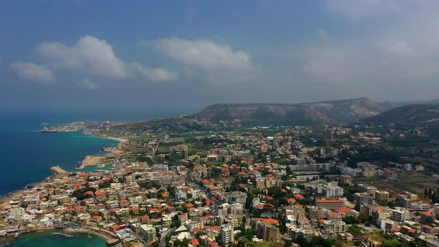 Aerial Panning Beautiful Shot Of Sea Against Cloudy Sky, Drone Flying Over Residential Buildings - Batroun, Lebanon