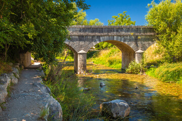 Fototapeta na wymiar Stone bridge on the lower reaches of the river Zrnovnica, near Split town in Croatia, Europe.