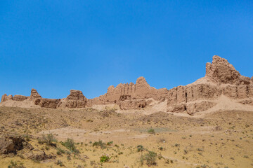 Fototapeta na wymiar Panorama of the walls of the ancient fortress Ayaz-Kala (Windy fortress). Fortification was built in the 3-4th century BC. Height of the walls reaches 10 m. Shot in the Kyzyl Kum desert, Uzbekistan