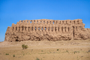 Obraz premium Well-preserved wall of Janbas Kala fortress. Height is about 10 m. Numerous rows of loopholes is visible. Fortification built in IV cent. BC. Shot in Kyzylkum desert, Karakalpakstan, Uzbekistan
