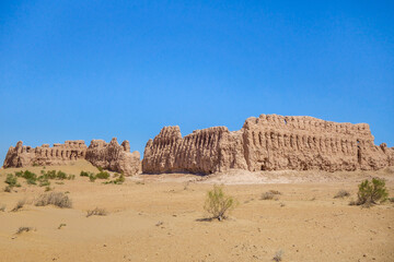Fototapeta na wymiar Main view of Janbas Kala fortress (IV century BC). Left: fortified entrance, center: break hole from ram attack. Height of walls is 10 m. Shot in Kyzylkum desert, Karakalpakstan, Uzbekistan