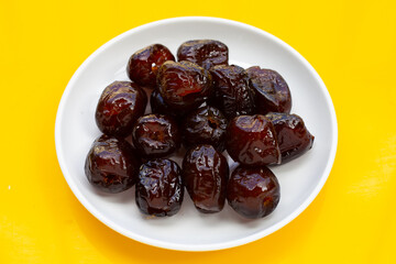 Sweet chinese jujube dessert in white plate on yellow background.