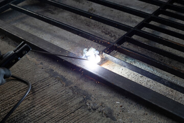 Iron gate repair, Worker hand welding steel