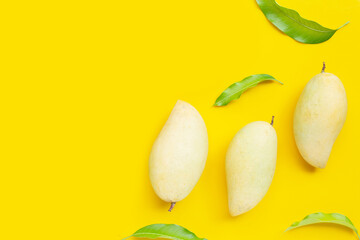 Tropical fruit, Mango with leaves on yellow background. Top view