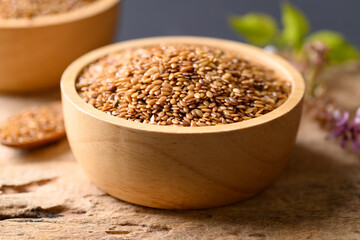 Close up of golden flax seed in bowl on wooden background