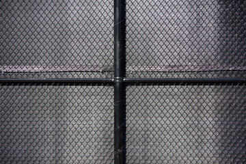 Full frame close-up view of a part of a black chain link fence with black fabric behind