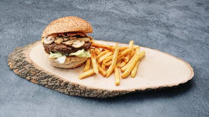  juicy caramelized mushroom burger with lettuce, cheddar cheese on a wooden tray front of a a vintage brick wall