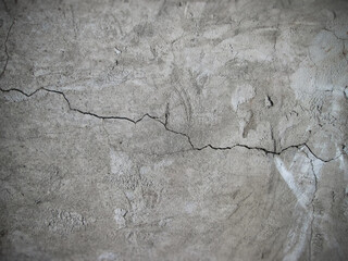 A long crack on a structural granular wall made of concrete and sand. Aging building material.