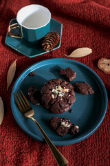 Chocolate Christmas Cookies on  green plate red background. Cozy home atmosphere. Festive homemade decorated sweets