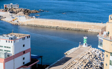 Green and white lighthouse on concrete pier