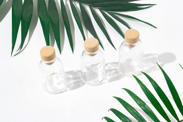 Three glass bottles with cork stoppers for perfumes with exotic plants. Mockup.