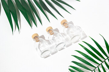 Three glass bottles with cork stoppers for perfumes with exotic plants. Mockup.