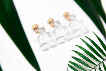 Three glass bottles with cork stoppers for perfumes with exotic plants. Mockup.