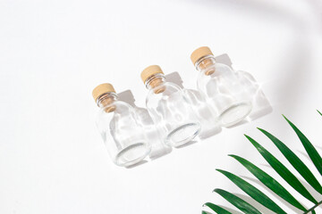 Three glass bottles with cork stoppers for perfumes with exotic plants. Mockup.