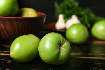 Fresh green tomatoes on dark wooden table, closeup