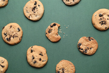 Tasty homemade cookies with chocolate chips on green background