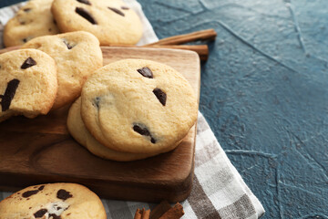Board with tasty homemade cookies on dark background, closeup