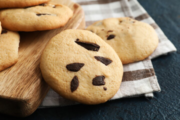 Board with tasty homemade cookies on dark background, closeup