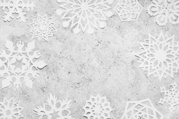 Frame made of beautiful paper snowflakes on light grunge background