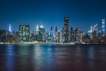 Plakat city skyline at night in new york with skyscrapers and buildings