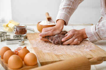 Woman preparing chocolate dough at kitchen table