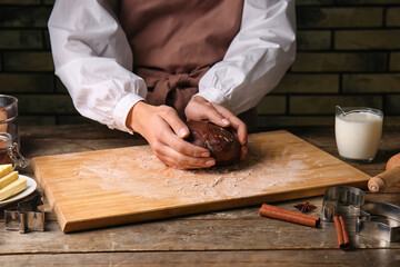 Woman preparing chocolate dough at kitchen table, closeup