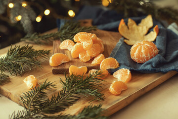 Fototapeta na wymiar Christmas atmosphere, tangerines among the yon branches against the background of lights