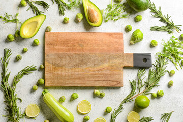 Wooden cutting board with green food on white background