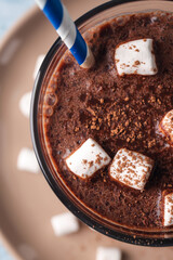 Glass of tasty hot chocolate with marshmallows on table, closeup