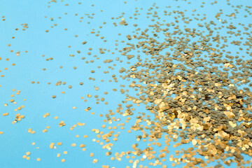 Heap of golden confetti on blue background