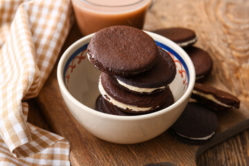 Bowl with tasty chocolate cookies on wooden table, closeup