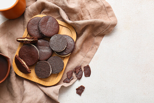 Board with tasty chocolate cookies on white background