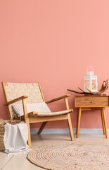 Armchair and table with lantern near color wall