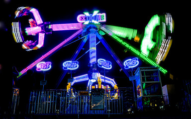 amusement park extreme spinning pendulum ride at night