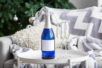 Bottle and glasses of champagne on table in living room