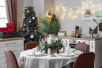 Dining table with beautiful setting for Christmas celebration in kitchen