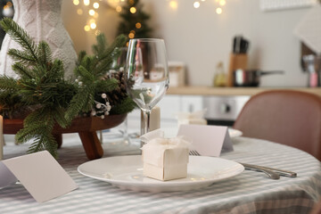 Dining table with beautiful setting for Christmas celebration and blank card, closeup