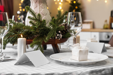 Dining table with beautiful setting for Christmas celebration and blank card, closeup
